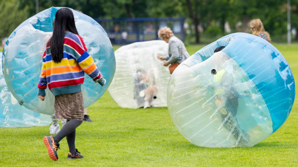 Attendees of 2024's Community Festival play in giant inflatable bubbles