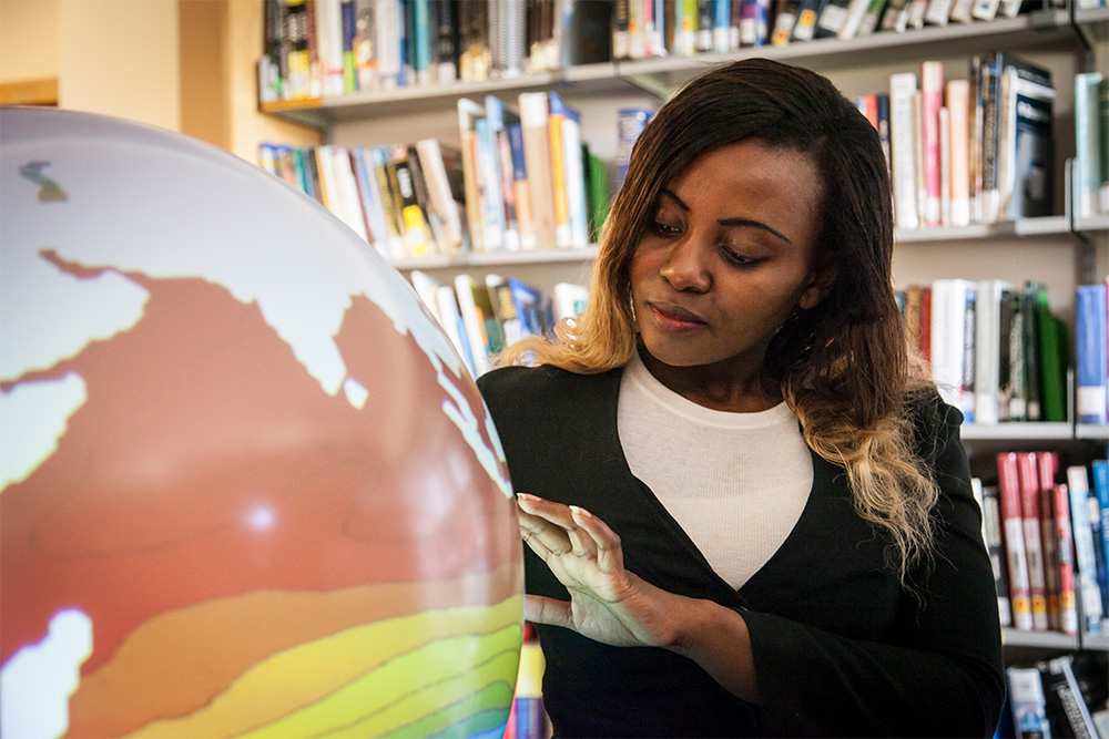 Chimene Daleu studying a meteorological globe