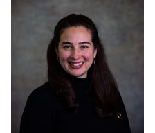 Headshot of woman with dark brown hair smiling at camera