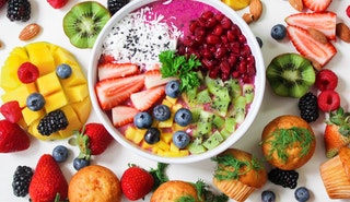 Assorted sliced fruit in white ceramic bowl