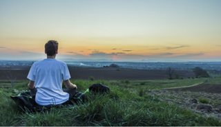 A man meditating in a field