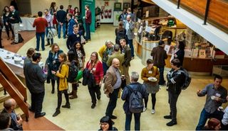 researchers standing in the foyer of the Palmer building, engaged in discussion