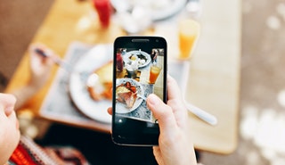 Person Holding Phone Taking Picture of Served Food