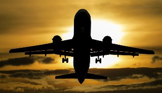 An aeroplane in front of a sunset