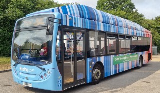 The climate stripes on the gas-powered bus thanks to the partnership between the university and Reading Buses