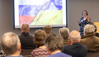 People listening to a talk at the Supporter Appreciation Evening