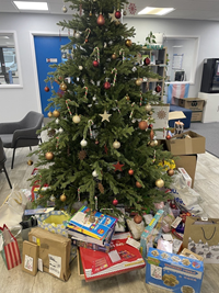 A decorated Christmas tree with lots of presents underneath