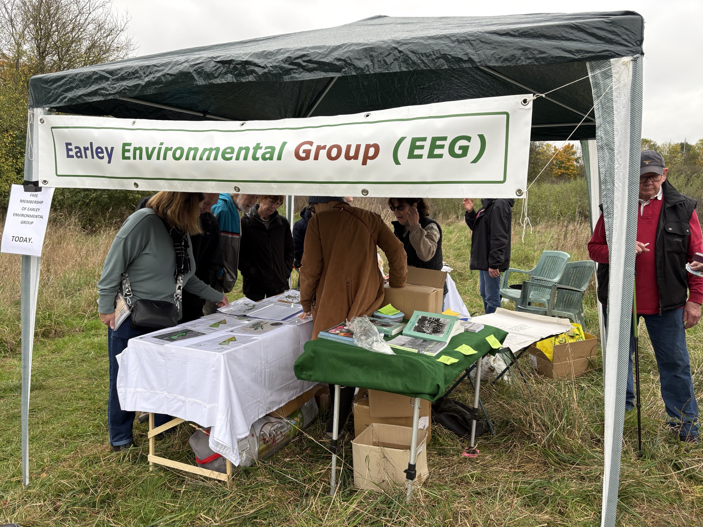 People gather around tables and a gazebo to review planning documents