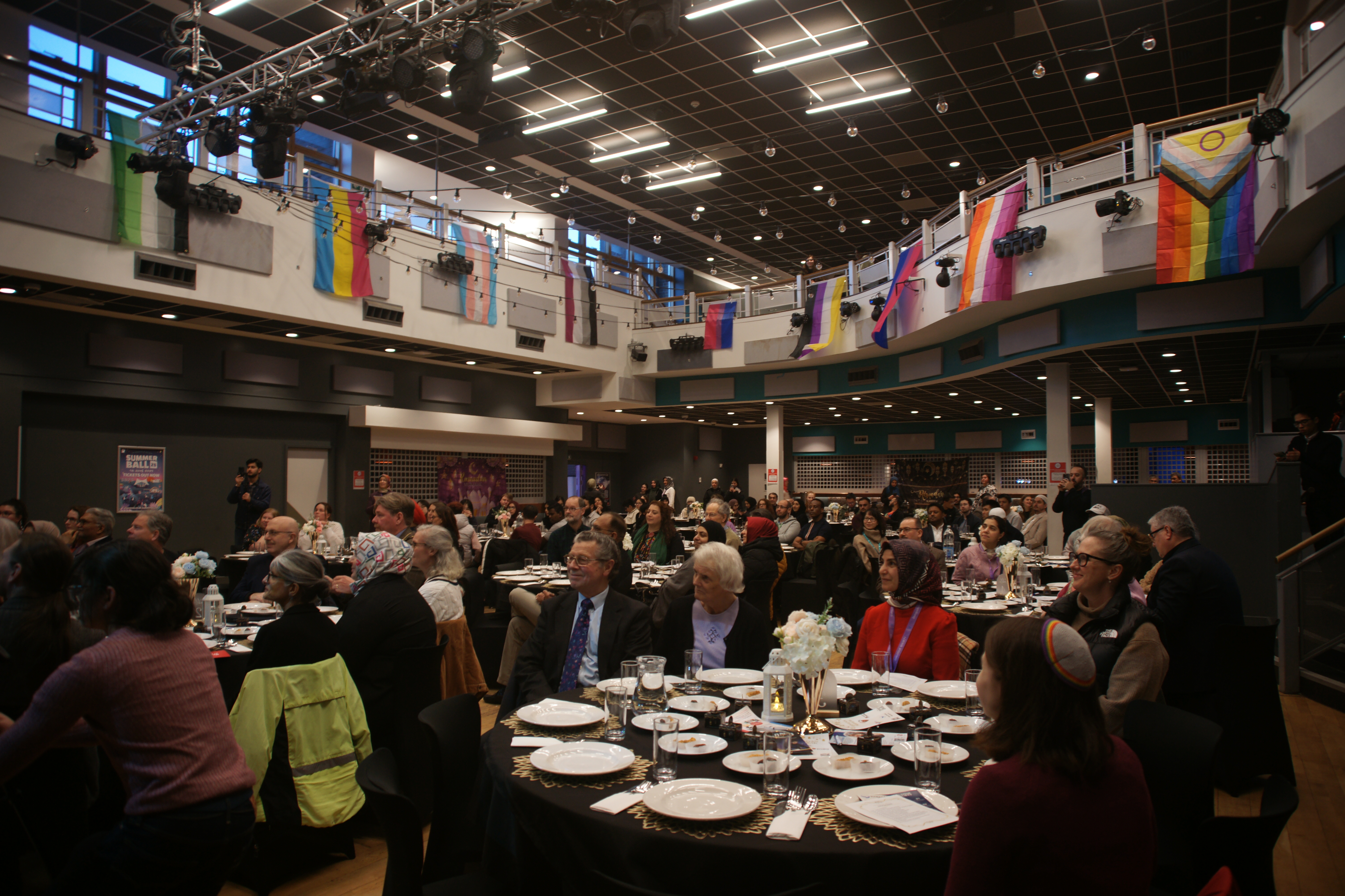 People enjoying speeches as a community iftar event