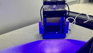 An image of a small machine emitting a blue light