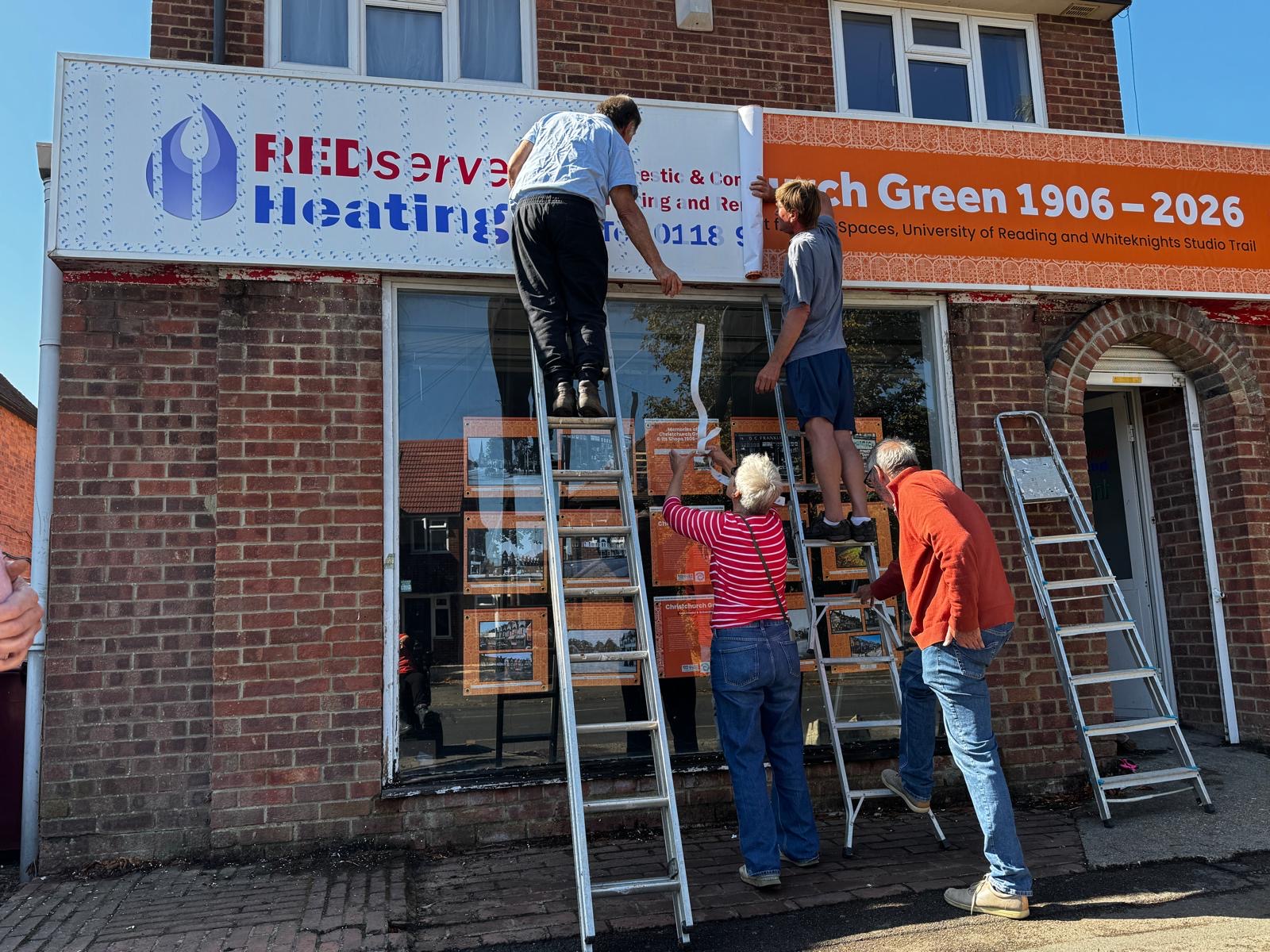 Members of the Friends of Christchurch Green putting the new exhibition signage up