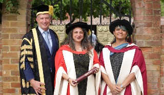 Three people in ceremonial graduation roles