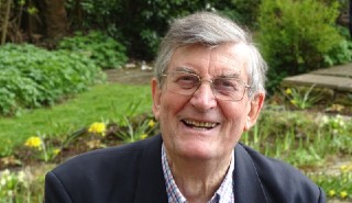 Emeritus Professor Keith Watson, photographed in a colourful garden