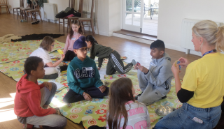 Children play card games with a Daisy's Dream staff member