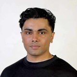 A man with dark hair and a black shirt