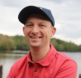 A man wearing a red polo shirt and cap