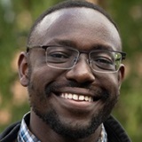 A man wearing a checked shirt and glasses