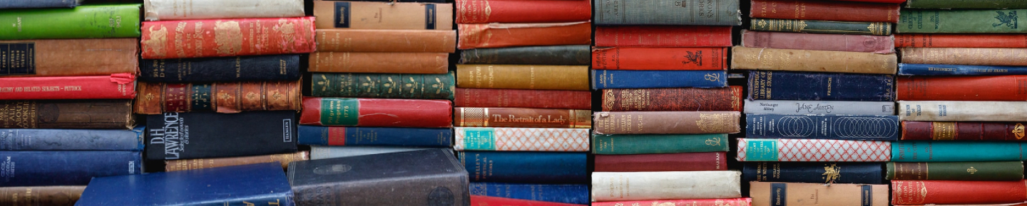 Stacks of colourful, worn, classic books, featuring authors such as D.H. Lawrence, Jane Austen and Henry James.