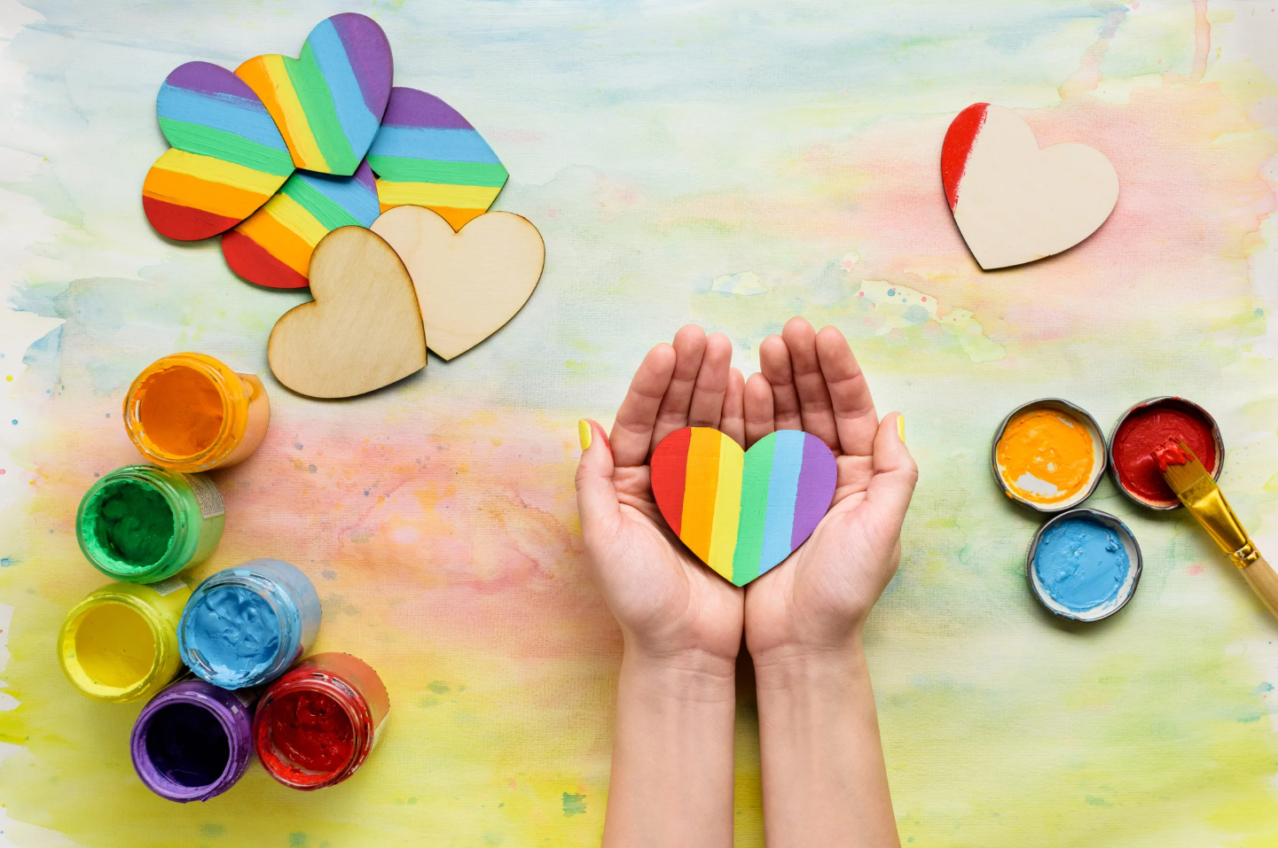 Hands holding a rainbow heart