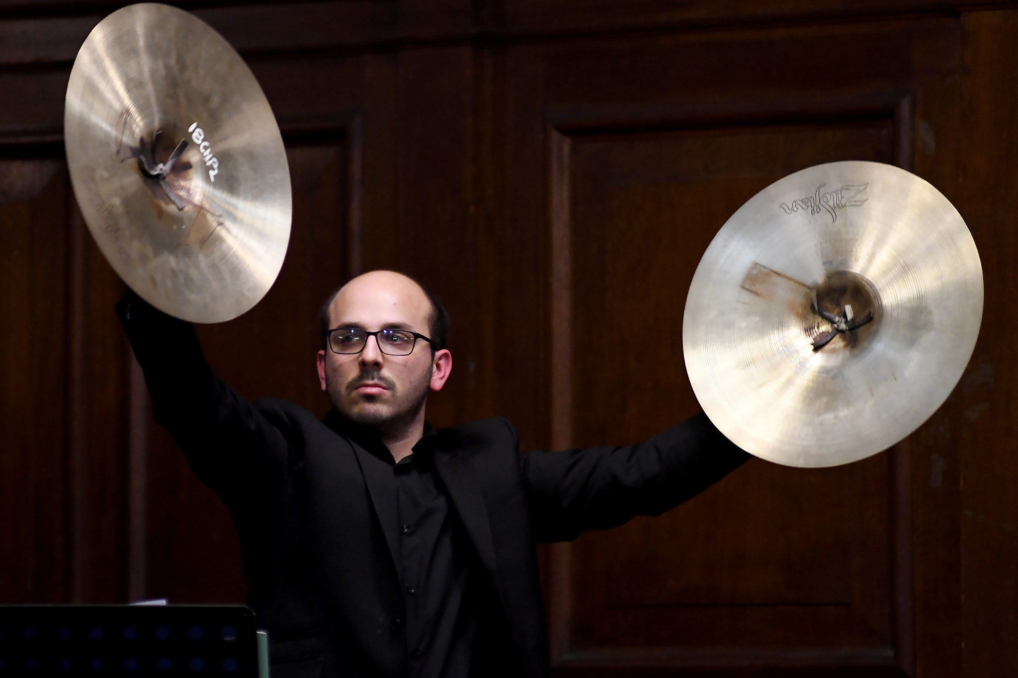 Man holding two large cymbals 