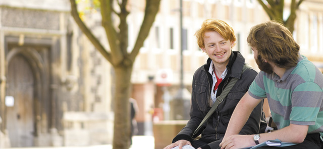 Students sitting on bench outside the town hall