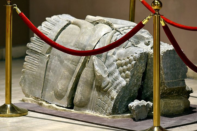 Ancient statuary remains known as 'head of lamassu' roped off in a museum exhibit