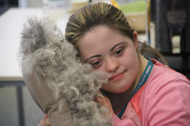 Girls holds a woolly cushion